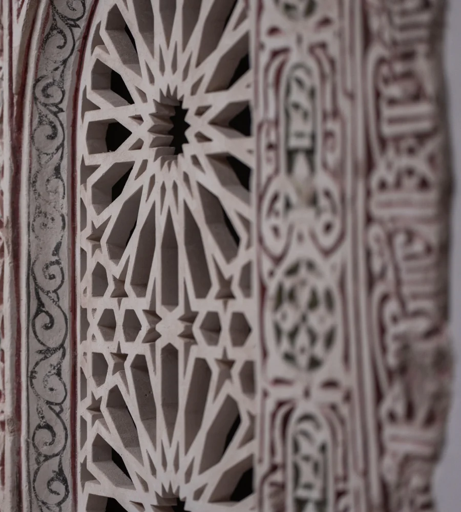 Panel decorativo con tallas geom&eacute;tricas blancas y fondo con patrones abstractos